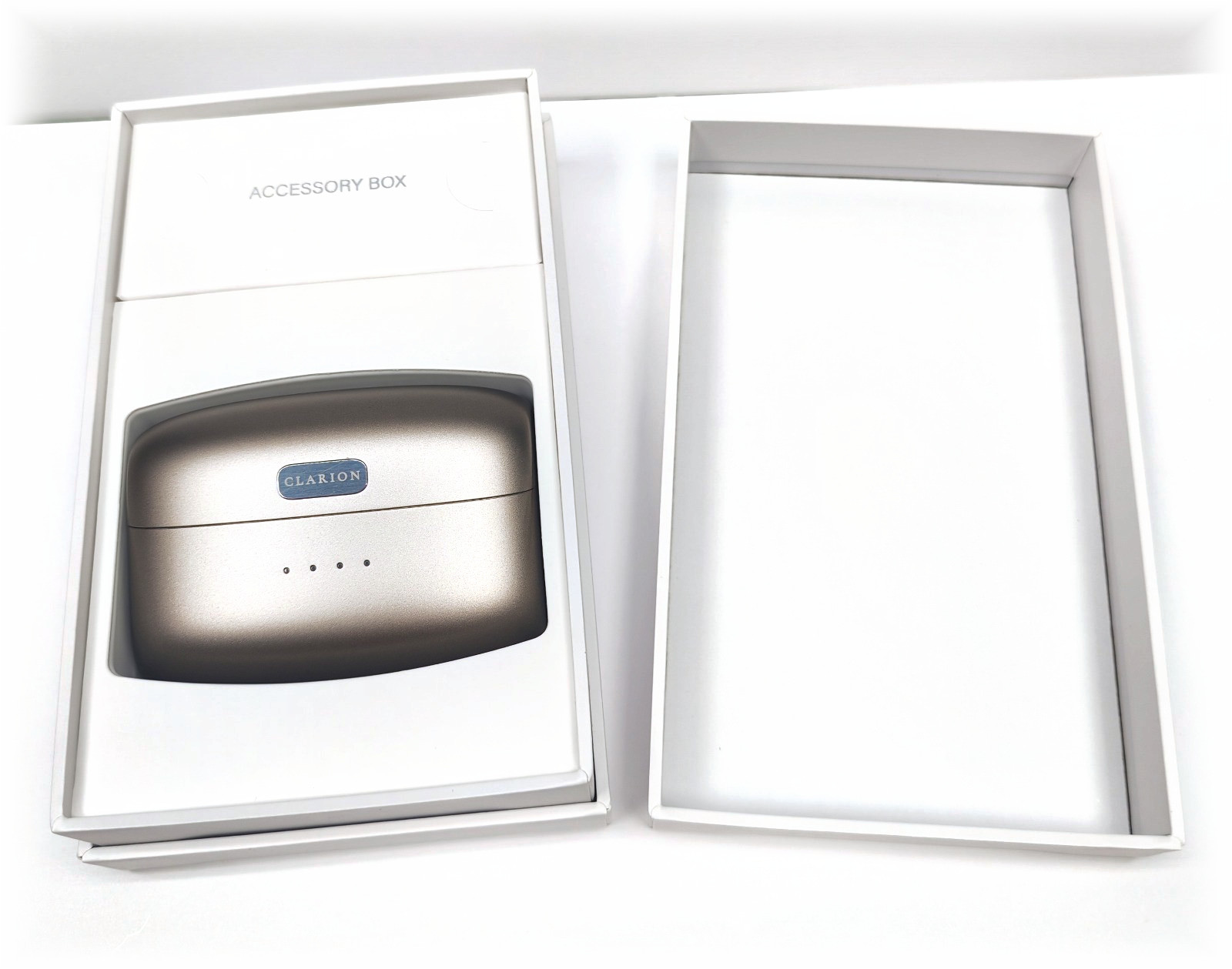 The Clarion presentation box open on white, the charging case seated inside it.